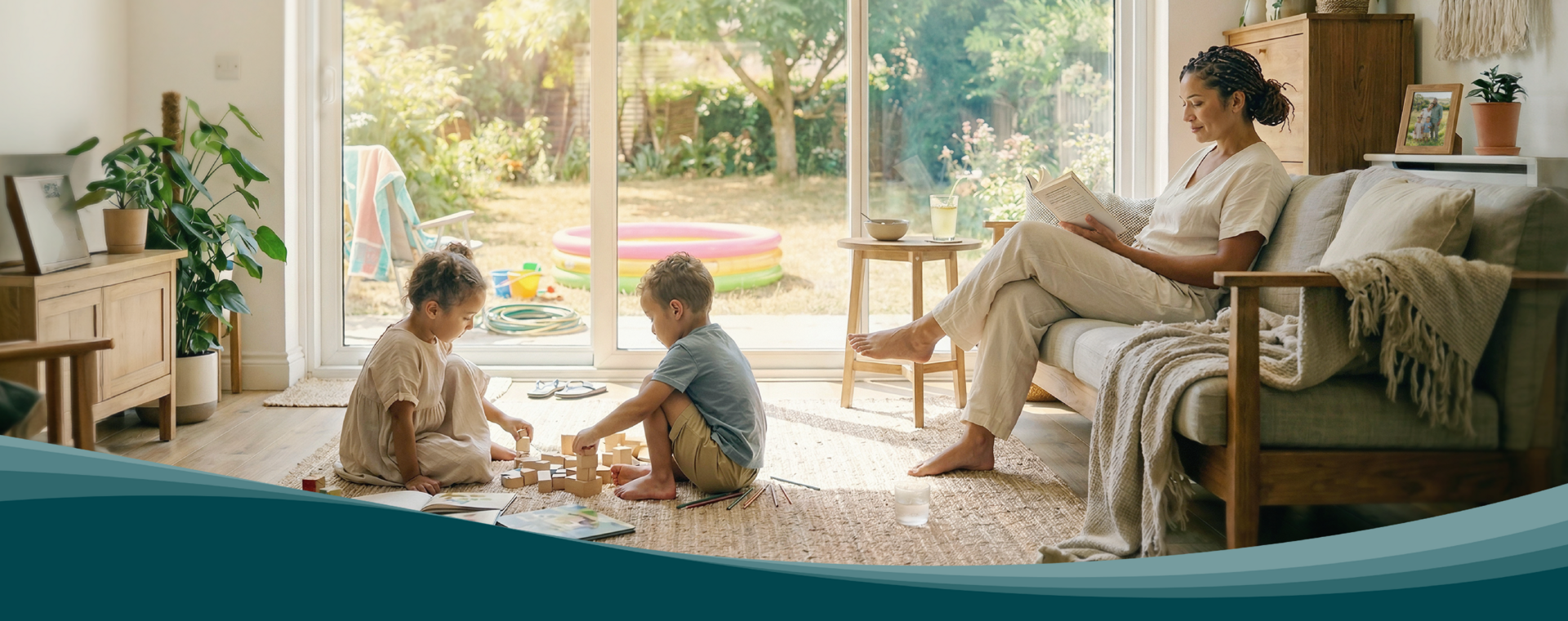 Living room with large windows facing the garden. Children play on a rug while a person reads on the sofa. Zehnder residential ventilation ensures air exchange.